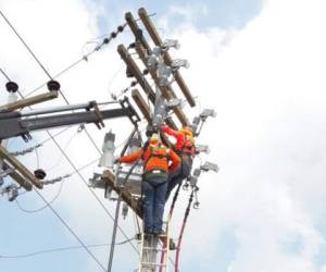 Empleado de la Empresa Energía Honduras realizán trabajos en uno de los postes.