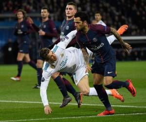 El delantero portugués del Real Madrid Cristiano Ronaldo cae sobre el defensor brasileño del Paris Saint-Germain Daniel Alves durante la ronda de octavos de final de la UEFA Champions League. Foto: AFP / CHRISTOPHE SIMON.