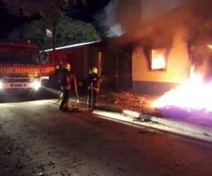 Miembros del Cuerpo de Bomberos de Honduras tratan de apagar las llamas.