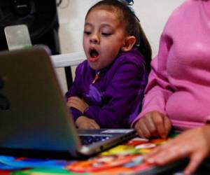 Liz, de 5 años, bosteza mientras sigue en línea una clase de prekínder. Foto AP.