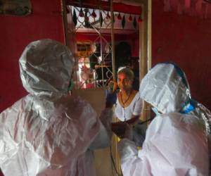 Personal sanitario realiza pruebas de síntomas de COVID-19 en un edificio de apartamentos en Dharavi, uno de los barrios pobres más grandes de Asia, en Mumbai, India. Foto AP.