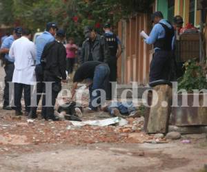 Crimen en colonia San Miguel. Personal forense carga los cadáveres para realizarles la respectiva autopsia. Fotos: EL HERALDO.