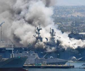 Una enorme columna de humo se eleva sobre el buque USS Bonhomme Richard en la base naval de San Diego. Foto AP.