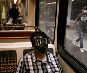 Ehab Hassanin usa una máscara mientras viaja en un tren de Metro Rail, el lunes 6 de julio de 2020, en Los Angeles, en los días del coronavirus. Foto AP.