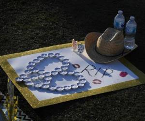 Una señal y un sombrero de vaquero dejados en un monumento improvisado se ven fuera del sitio del festival de música de la ruta 91 al lado del hotel de Mandalay el 4 de octubre de 2017 en la tira de Las Vegas, después de que un pistolero mató a 59 personas e hirió a más de 500 otros cuando él abrió el fuego desde el Hotel Mandalay en un festival de música country en Las Vegas, Nevada. El presidente Donald Trump se dirige a Las Vegas para reunirse con las víctimas de los disparos masivos y los primeros socorristas, así como con los investigadores que esperan que la novia del pistolero Stephen Paddock pueda ayudar a levantar el misterio que rodea la masacre del fin de semana. / AFP / Mark RALSTON