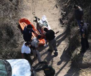 HIDALGO, TX - JANUARY 03: (EDITORS NOTE: Image depicts death.) Rescue crews and U.S. Border Patrol agents remove a dead body from the banks of the Rio Grande on January 3, 2017 near Hidalgo, Texas. Thousands of immigrants are surging across the border ahead of the inauguration of President-elect Donald Trump, who has vowed to strengthen border security. Every year hundreds of immigrants die while making the perilous journey into the United States. John Moore/Getty Images/AFP== FOR NEWSPAPERS, INTERNET, TELCOS & TELEVISION USE ONLY ==