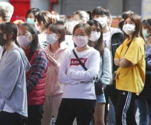 People wear face masks to protect against the spread of the coronavirus in Taipei, Taiwan, Wednesday, Feb. 26, 2020. (AP Photo/Chiang Ying-ying)