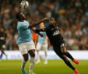 El hondureño Juan Carlos García disputa el balón con el inglés Micah Richards del Manchester City.