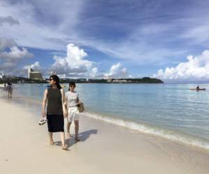 Los turistas caminan por la playa en Tumon, Guam. (Foto: AP/ El Heraldo Honduras/ Noticias de Honduras)