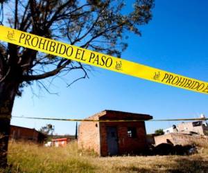 El área alrededor de una fosa común clandestina descubierta en el barrio de El Mirador en Tlajomulco de Zuniga, estado de Jalisco, México, está acordonada como personal de la Oficina del Fiscal Especial para Personas Desaparecidas que trabaja en el sitio, el 13 de enero de 2020.