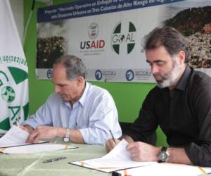 El edil Asfura y Bernard McCaul, de Goal, durante la firmadel convenio para reubicar a 74 familias en la colonia Berlín.