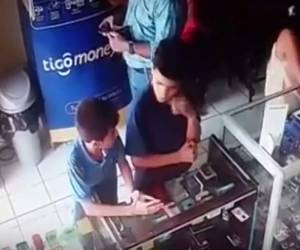 En las imágenes se puede ver como los dos menores de unos 12 a 14 años de edad en un descuido sacan uno de los aparatos telefónicos sin ser notados por los empleados del negocio.