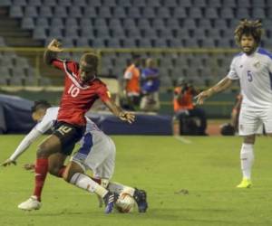Kevin Molino pelea el balón ante la marca del rival en el juego que se disputó en el estadio Hasely Crawford de Puerto España (Foto: Agencia AFP)