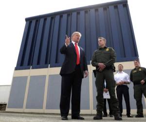 En esta fotografía del 13 de marzo de 2018, el presidente Donald Trump habla durante una revisión de los prototipos para el muro fronterizo en San Diego, mientras Rodney Scott, jefe del sector de San Diego de la Patrulla Fronteriza, lo escucha. (AP Foto/Evan Vucci, Archivo)