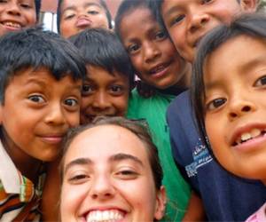 María Lucaya, estudiante de segundo de Filología Hispánica y Comunicación Audiovisual, sonríe junto con un grupo de niños hondureños a los que ayudó este verano como voluntaria. Foto: fcompass.
