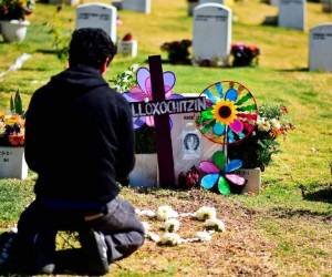 El activista mexicano Daniel Atilano coloca flores en la tumba de una niña, aún no identificada en ese momento, que fue encontrada asesinada el 18 de marzo de 2017 en el estado de México, en un cementerio en Naucalpan, al noroeste de la Ciudad de México. Agencia AFP.