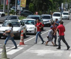 Adultos y niños se aventuran a cruzar transitadas calles de la capital, situación que pone en peligro sus vidas. Foto: Efraín Salgado/EL HERALDO.