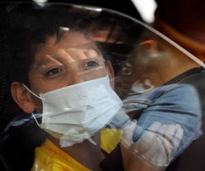 Un niño que usa una máscara médica como precaución contra la propagación del nuevo coronavirus, mira por la ventanilla de un automóvil en la Ciudad de México, el sábado 29 de febrero de 2020. El Departamento de Salud de México dijo el viernes por la noche que se había confirmado un nuevo caso en la Ciudad de México. , agregando a los dos primeros casos confirmados anunciados ese mismo día. (Foto AP / Marco Ugarte)