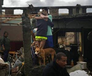 Una pareja se abraza entre los restos de su casa destruida por el huracán Matthew en la ciudad de Baracoa, en Cuba. /Foto AP/