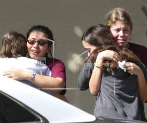 Students grieve outside Pines Trail Center where counselors are present, after Wednesday's mass shooting at Marjory Stoneman Douglas High School in Parkland, Fla., Thursday, Feb. 15, 2018. Nikolas Cruz was charged with 17 counts of premeditated murder Thursday morning. (AP Photo/Joel Auerbach)