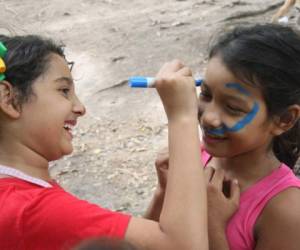 Astrid Fúnez se divierte pintando caritas a otros niños durante una celebración.