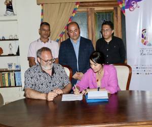 Momento en que Mayra Oyuela firma como la primera poeta que viajará a Quebec, Canadá, en representación de Honduras.