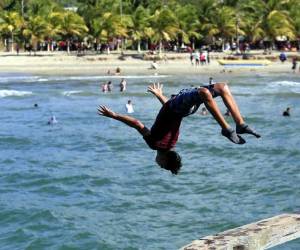Los turistas y visitantes locales de la ciudad costera aprovechan la altura del muelle para hacer clavados. Foto: EL HERALDO/Marvin Salgado