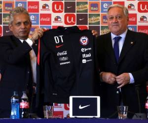 El colombiano Reinaldo Rueda (izq.) Muestra su chaqueta como entrenador del equipo nacional de Chile junto a Arturo Salah, presidente de la Asociación Nacional de Fútbol Profesional de Chile en Santiago, el 19 de enero de 2018.Rueda asumió como nuevo entrenador del equipo nacional de Chile. / AFP / CLAUDIO REYES