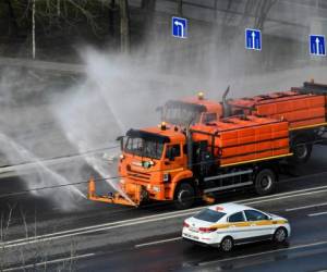 A municipal vehicle disinfects a street on the outskirts of Moscow on March 28, 2020, as the city attempts to curb the spread of the COVID-19, the disease caused by the novel coronavirus. (Photo by Kirill KUDRYAVTSEV / AFP)