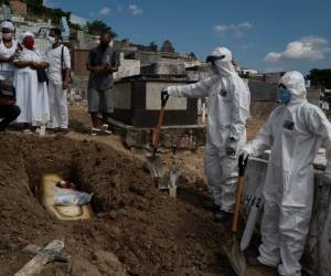 En esta imagen, tomada el 28 de abril de 2020, Taina dos Santos (tercera por la izquierda) asiste al entierro de su madre, Ana María, una auxiliar de enfermería de 56 años que falleció por el coronavirus, en Río de Janeiro, Brasil. (AP Foto/Leo Correa)