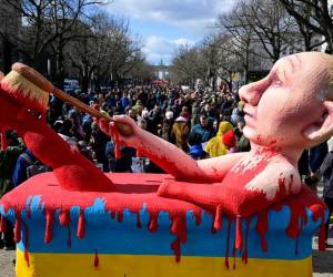 Una efigie del presidente ruso Vladimir Putin bañándose en un baño de sangre se ve en una manifestación frente a la embajada rusa en Berlín, donde los votantes hicieron fila para emitir su voto en las elecciones presidenciales de Rusia. El resultado preliminar muestra a Putin como ganador de las elecciones, sería el quinto mandato consecutivo con el que sumaría 30 años en el poder.