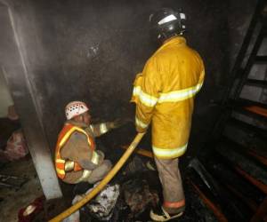 Personal del Cuerpo de Bomberos mientras sofocaban las llamas de la vivienda.