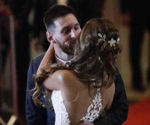 Recién casados ​​Lionel Messi y Antonella Roccuzzo besan mientras posan para fotógrafos en la alfombra roja después de atar el nudo en Rosario, Argentina. Foto AP.