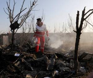 Un rescatistas busca entre los escombros en el lugar donde se estrelló un avión de pasajeros ucraniano, en Shahedshahr, al suroeste de Teherán, Irán, el 8 de enero de 2020. (AP Foto/Ebrahim Noroozi)