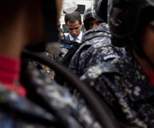 El presidente de la Asamblea Nacional Juan Guaidó con el paso bloqueado por policías para ingresar al inmueble donde se prevé que dirija una sesión para elegir el nuevo liderazgo de la Asamblea, en Caracas, el domingo 5 de enero de 2020. (AP Foto/Andrea Hernandez Briceño)