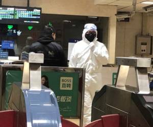 Un agente de seguridad viste un traje de seguridad en una estación de metro en Beijing, el 24 de enero de 2020. (AP Foto/Yanan Wang)