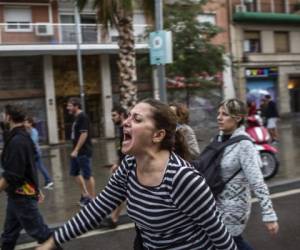 Una mujer grita durante los enfrentamientos con policías españoles fuera del colegio electoral de Ramón Llull en Barcelona el 1 de octubre de 2017 durante un referéndum sobre la independencia de Cataluña prohibido por Madrid.La policía antidisturbios española disparó balas de goma y se introdujo el domingo en las mesas electorales de Cataluña, mientras miles de personas inundaban las calles para votar en un referéndum de independencia prohibido por Madrid./ AFP / Fabio Bucciarelli