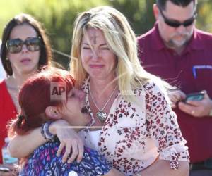 Padres esperan por noticias tras el reporte de un tiroteo en la Escuela Secundaria Marjory Stoneman Douglas de Parkland, Florida, el miércoles 14 de febrero de 2018. (AP Foto/Joel Auerbach)