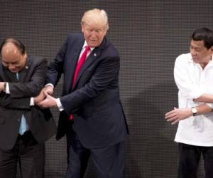 Las instrucciones desconcertaron brevemente a Trump, que al principio simplemente cruzó sus manos por delante. (Foto: AP/ El Heraldo Honduras/ Noticias Honduras hoy)