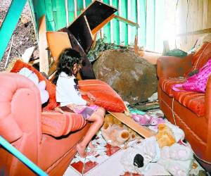 La nieta de don Rigoberto observa a sus peluches mojados entre el caos. Foto: Estanlin Irias / EL HERALDO.