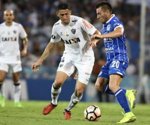 Uilson del Atlético Mineiro junto a Ángel González del Godoy Cruz en acción por la Copa Libertadores en el Estadio Malvinas Argentinas en Mendoza, Argentina. AFP PHOTO / Andres Larrovere.