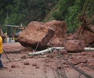 Parte de las gigantesca rocas que cayeron sobre la vía producto del derrumbe en la colonia Villa Nueva. Unas ocho horas se trabajó para abrir el paso a los vehículos en la zona. Foto: Efrain Salgado/El Heraldo.