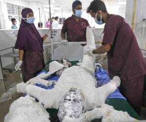 Varios médicos atienden el sábado 5 de septiembre de 2020 a una persona que se quemó al estallar un gasoducto junto a la mezquita en la que se encontraba, en Daca, Bangladesh.