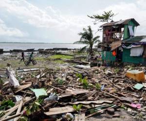 Tacloban, Filipinas: (ARCHIVOS) En esta foto de archivo tomada el 25 de diciembre de 2019, los residentes pasan junto a una casa dañada durante el tifón Phanfone en Tacloban, provincia de Leyte, en el centro de Filipinas. El 29 de diciembre de 2019, las autoridades dijeron que el número de muertes por una tormenta poderosa que azotó Filipinas en Navidad aumentó a 41, y que decenas de miles de locales permanecen en centros de evacuación. / AFP / Bobbie ALOTA