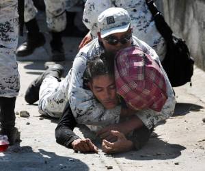 Un elemento de la Guardia Nacional de México detiene a un migrante centroamericano que cruzó el río Suchiate de Guatemala a México, cerca de Ciudad Hidalgo, México, el lunes 20 de enero de 2020. (AP Foto/Marco Ugarte)