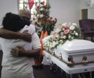 Darryl Hutchinson, de frente, recibe el abrazo de un pariente durante el funeral de Lydia Nunez, prima del primero, en la Iglesia Bautista Metropolitana en Los Ángeles. Lydia Nunez falleció de COVID-19. (AP Foto/Marcio Jose Sanchez, Archivo).