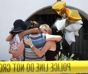Varias personas se abrazan frente a la iglesia donde ocurrió la masacre. (Foto: AFP)