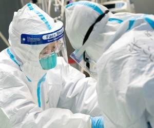 En esta fotografía proporcionada por la agencia de noticias china Xinhua, unos trabajadores médicos atienden a un paciente en el Hospital Zhongnan, en Wuhan, China, el viernes 24 de enero de 2020. (Xiong Qi/Xinhua vía AP)