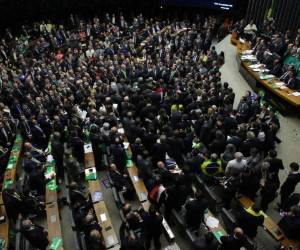 Demonstrators holds signs that read in Portuguese: 'Remove him now!' and 'Get out Temer,' referring to Brazil's President Michel Temer outside a presidential office building in Sao Paulo, Brazil, Tuesday, June 6, 2017. Brazil’s Superior Electoral Court planned to begin Tuesday evening the judgment phase of a trial involving allegations that the 2014 Rousseff-Temer ticket received illegal campaign financing. The court is expected to meet for three days and could make a ruling this week. (AP Photo/Andre Penner)