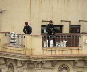 La policía armada vigila mientras el rey Felipe y la reina Letizia de España depositan flores en un homenaje de flores, mensajes y velas a las víctimas del ataque de las furgonetas en el paseo de Las Ramblas en Barcelona.